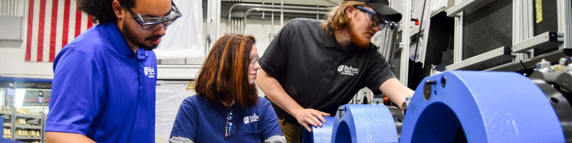 Workers inspecting machine in factory