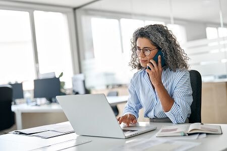 Woman talking on phone with laptop