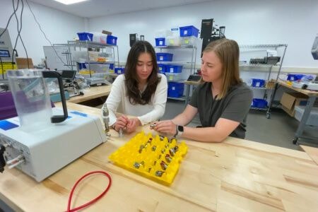 Two women reviewing tools on a table