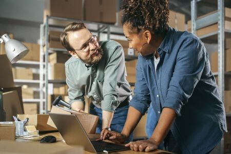 Two workers talking a warehouse