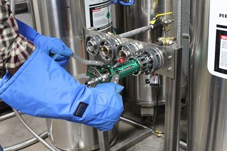 Worker applying nozzle to cryogenics machine
