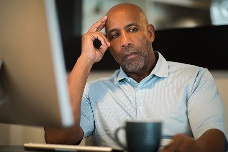 Man thinking in front of a computer