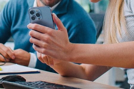 Woman showing a man photos on a cell phone