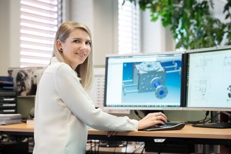Woman smiling next to a computer screen