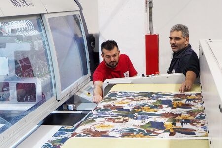 Two men working a large format printer