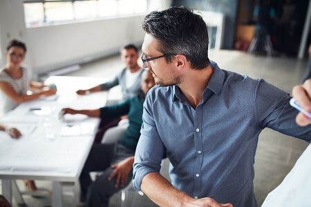 Man at whiteboard in conference room
